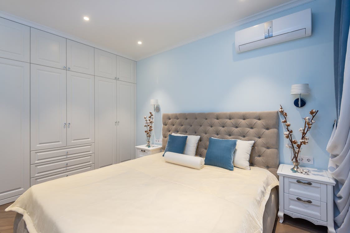 A bedroom with an AC unit on the wall